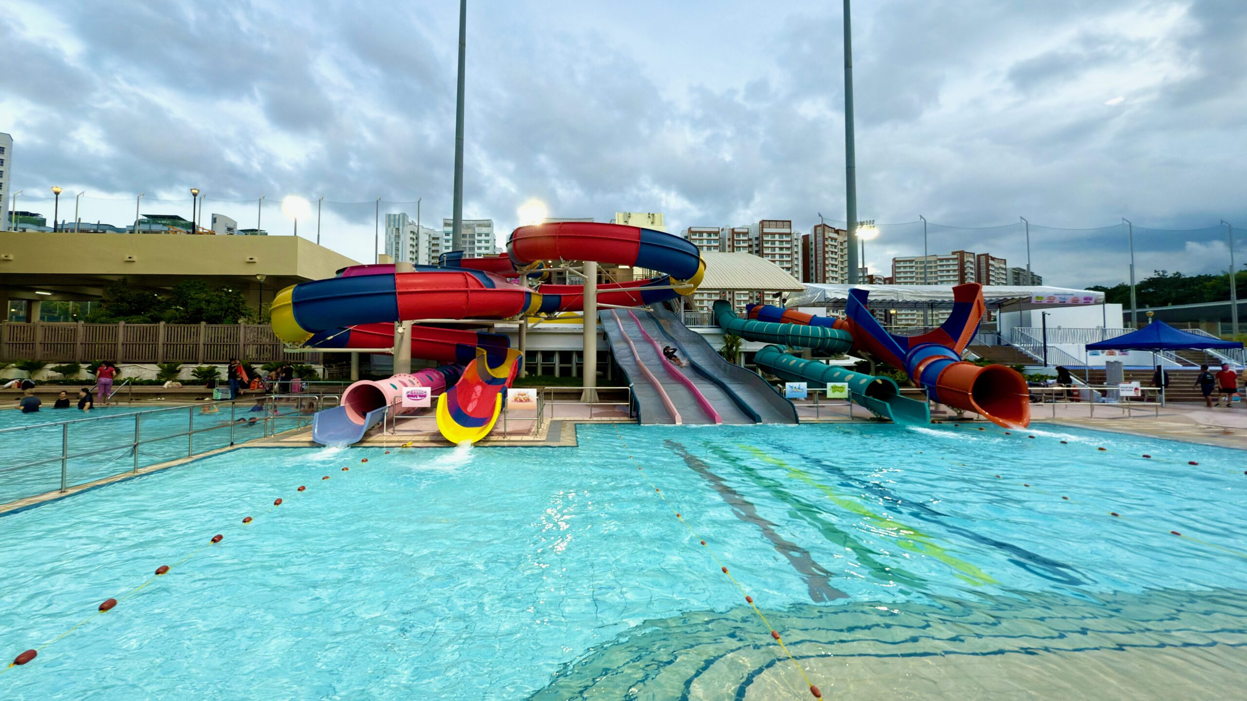 Brightly coloured water slides at Sengkang Swimming Complex with a clear view of the landing pool and splash zone.